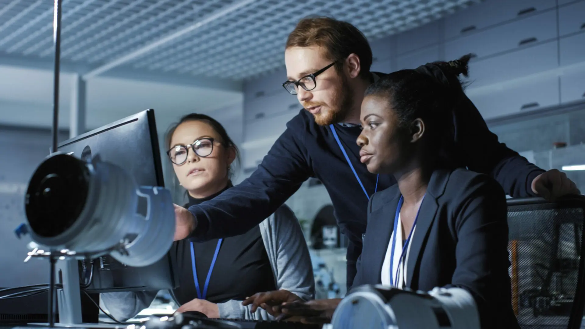 A woman pointing at the screen to show to her colleague