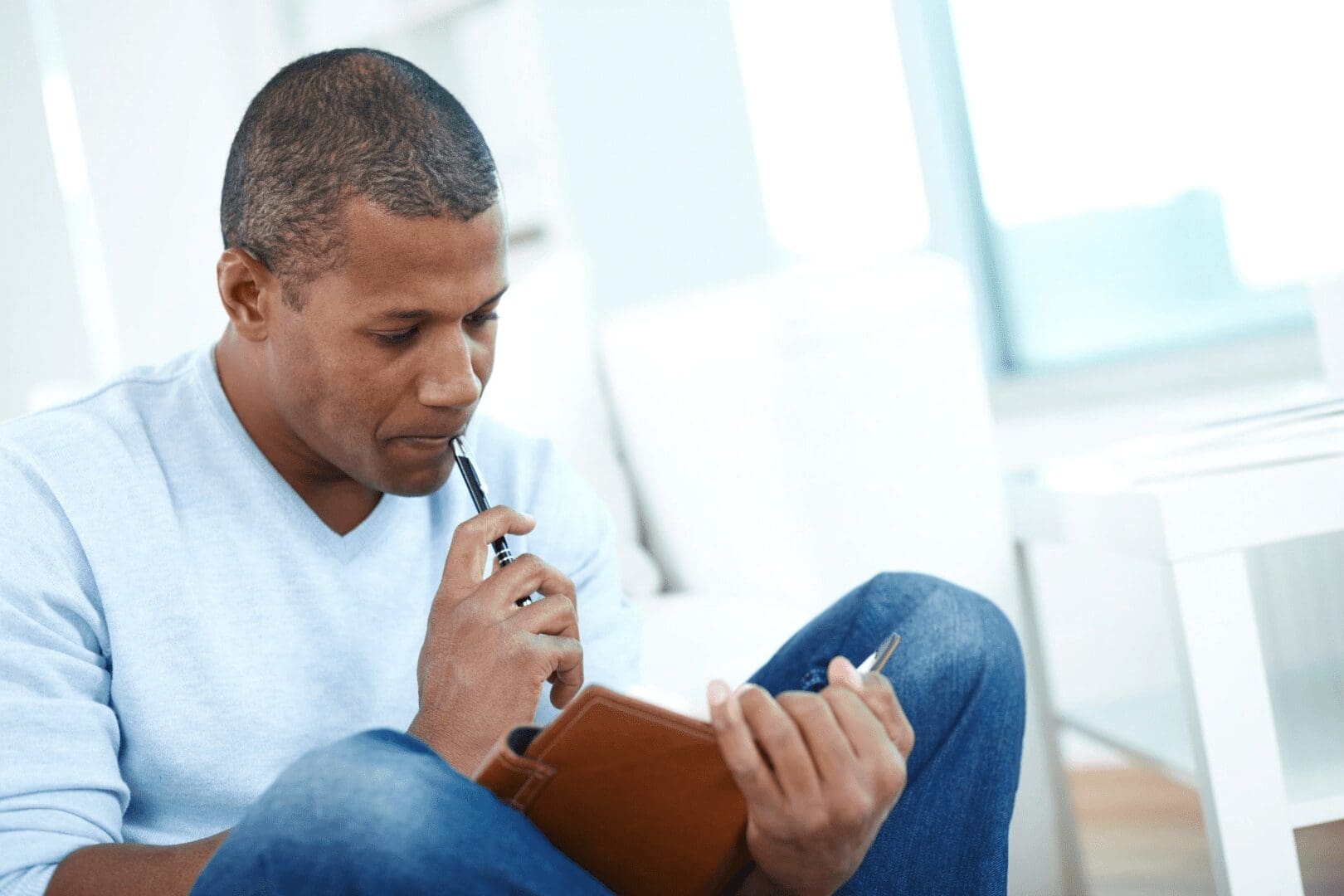 A man in a white shirt thinking and reading his notes