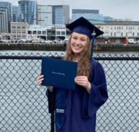 Graduation day with a proud smile holding a diploma.