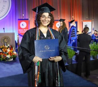 Graduation day with a proud smile holding a diploma.